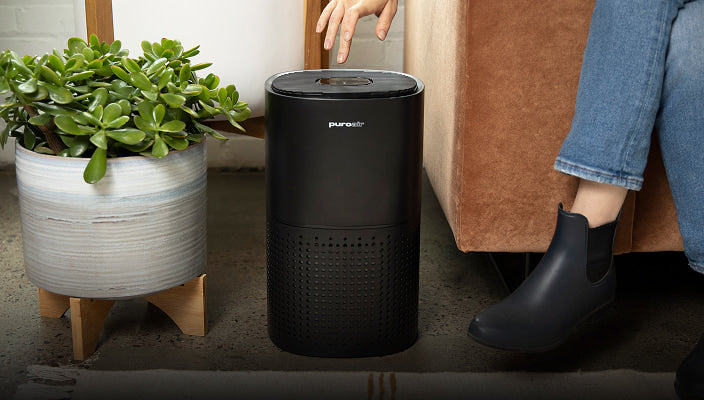 puroair 240 air purifier on ground by couch and house plant