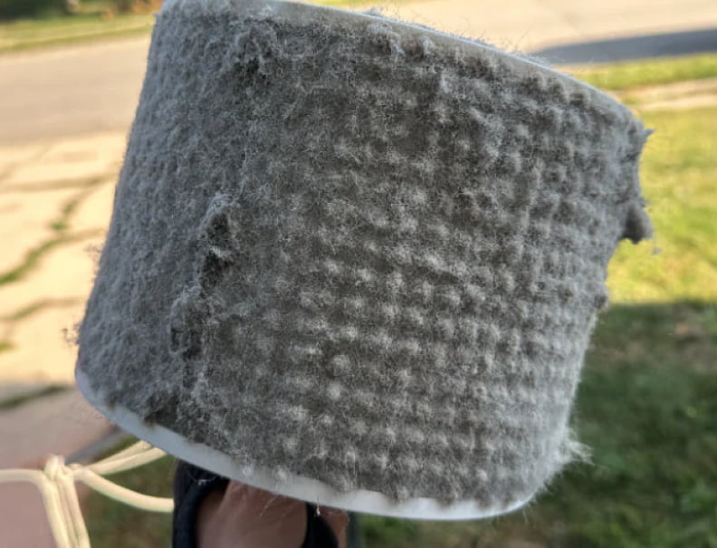 Dirty PuroAir 240 filter held outdoors with a blurred background