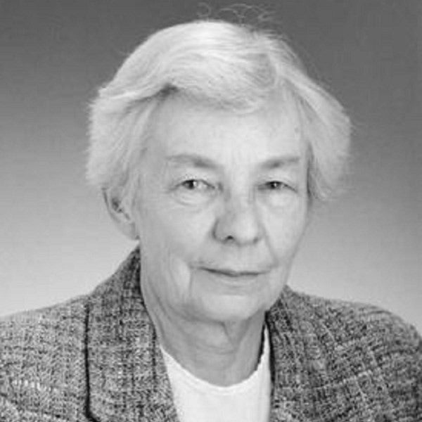 headshot of woman wearing light shirt and tweed jacket