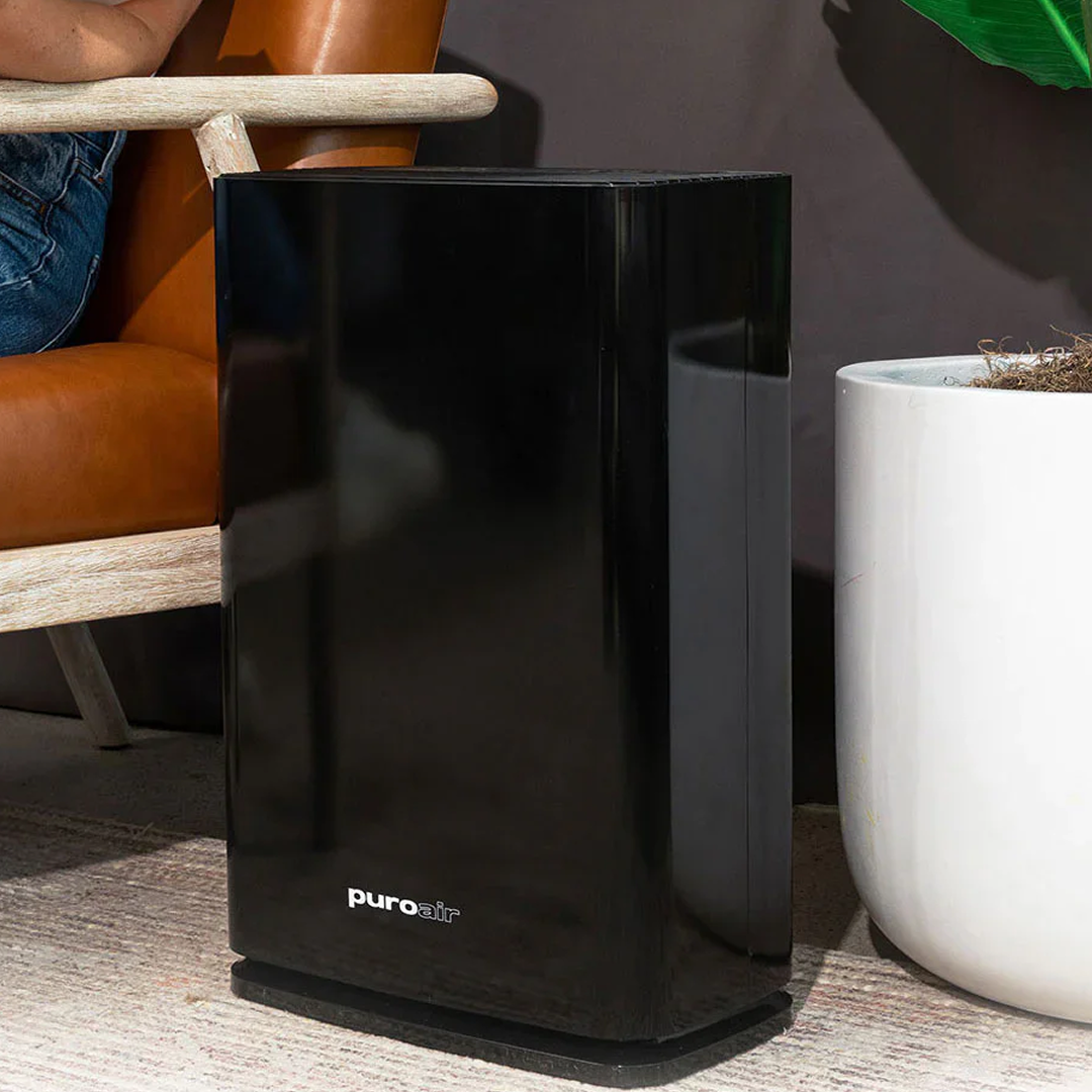 PuroAir 400 Air Purifier on ground in-between houseplant and chair