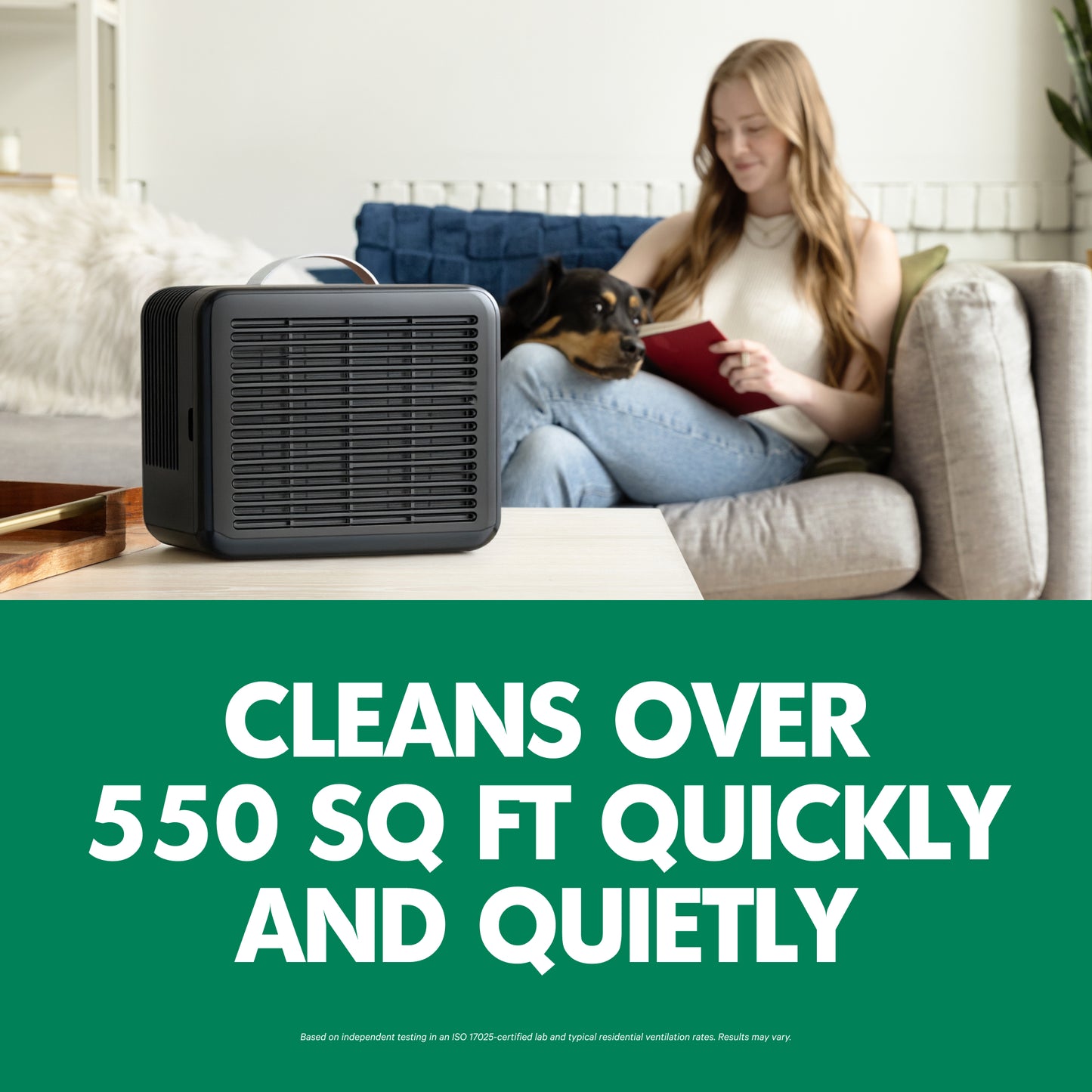Woman reading book with dog on couch next to PuroAir 100i air purifier