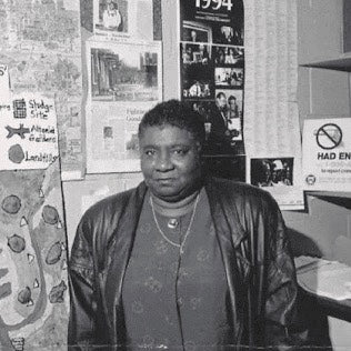 woman wearing blouse and jacket standing next to wall with posters