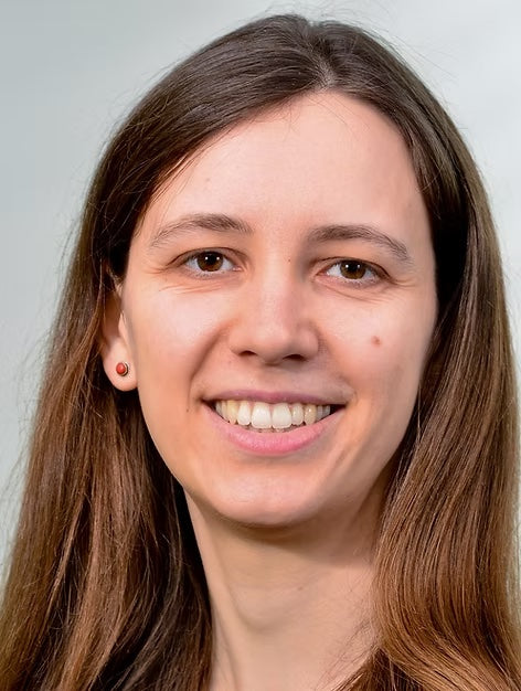 headshot of woman smiling with red earrings